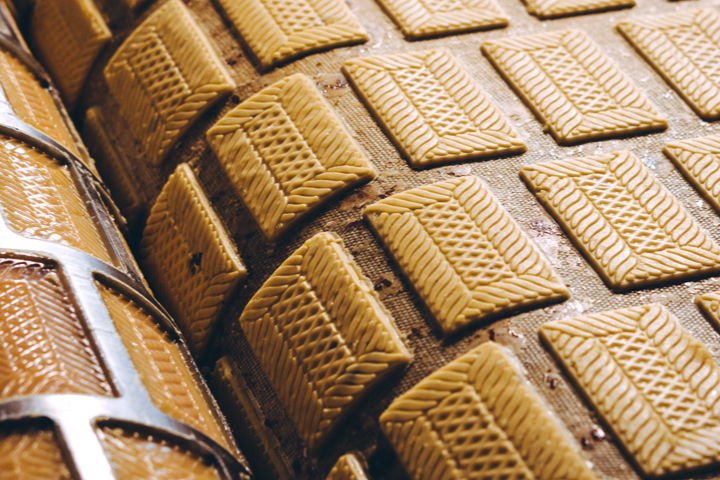 a grid of cookie biscuits being made in a food manufacturing facility